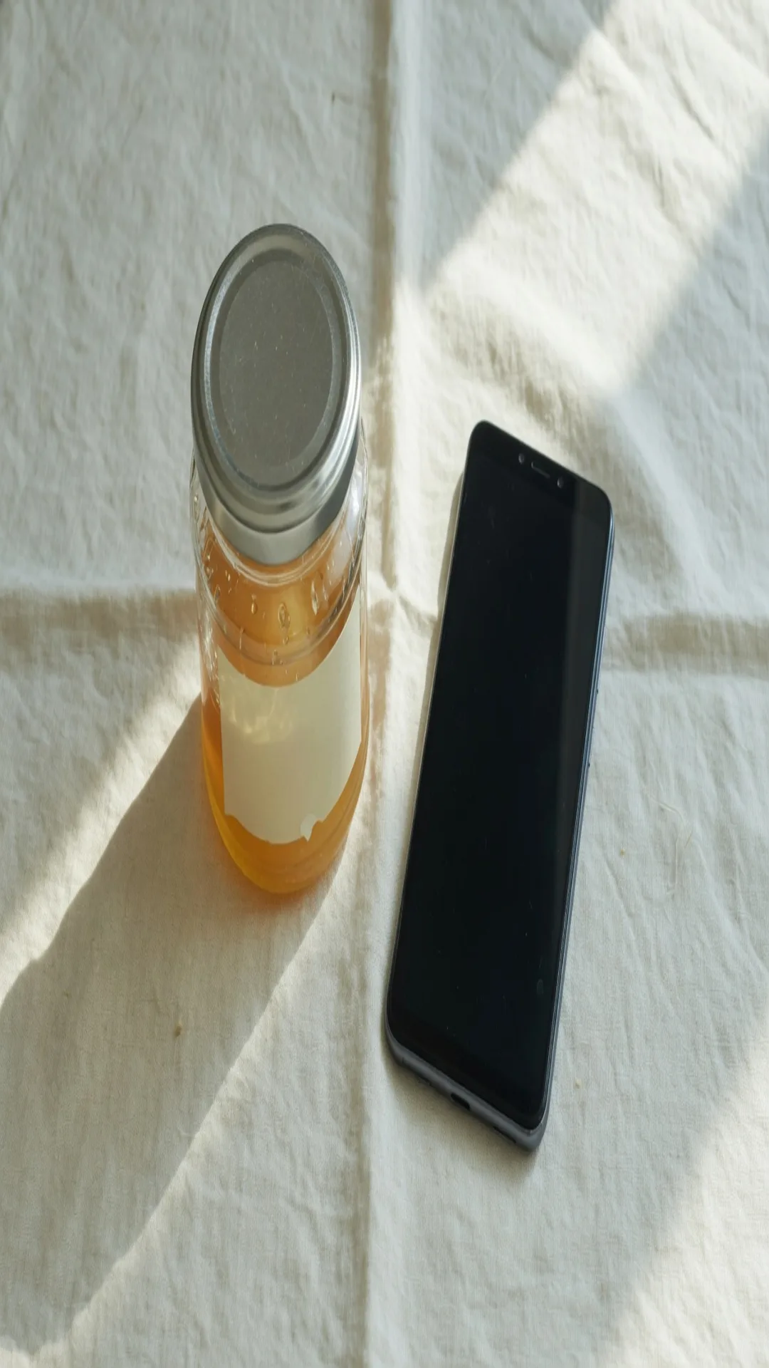 The same jar and phone stretched to 1080 by 1920, the lid a tall ellipse, the label and the phone still in the file