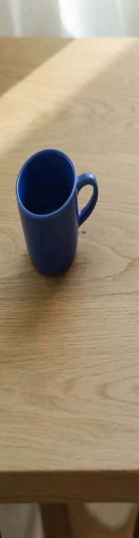 The left edge of the stretched square, with the cobalt cup still in the file and pulled into an oval