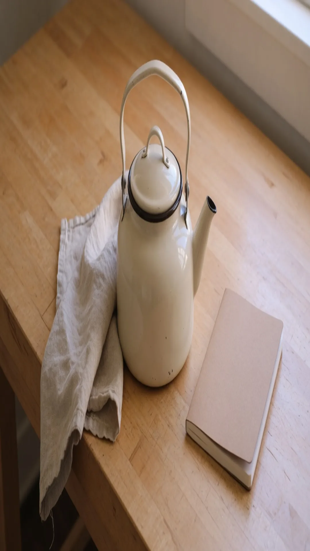 The kettle photograph stretched to 1080 by 1920, the round belly now a tall ellipse, linen and notebook still in frame
